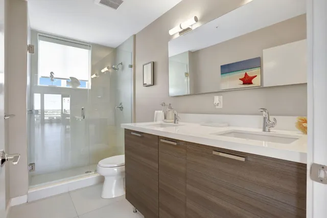 a bathroom with a sink a toilet and shower