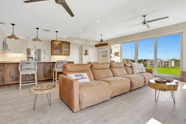a living room with a couch and a dining table with wooden floor