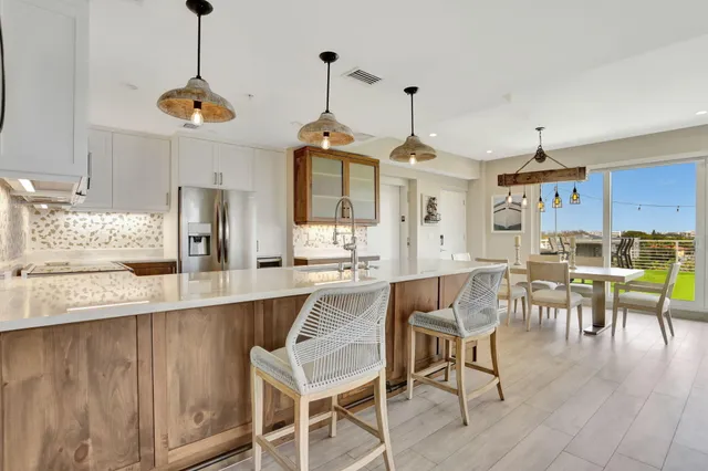 a view of a dining room and livingroom with furniture wooden floor a chandelier