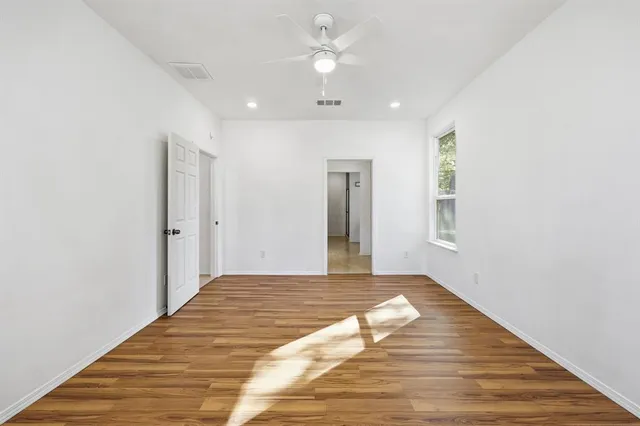 a view of a livingroom with wooden floor and a ceiling fan