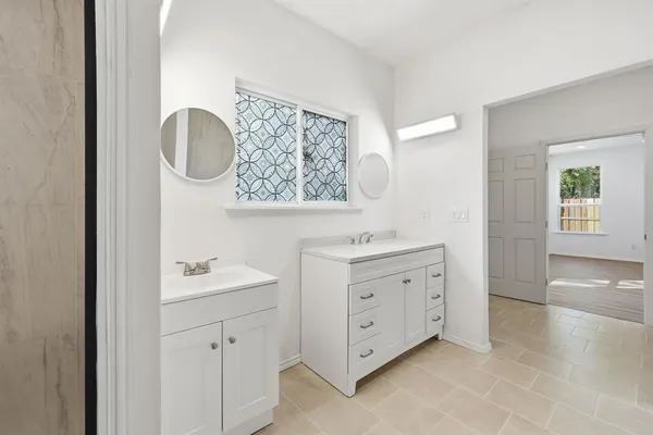a spacious bathroom with a double vanity sink a mirror and a