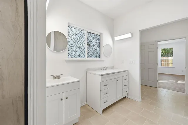 a spacious bathroom with a double vanity sink a mirror and a