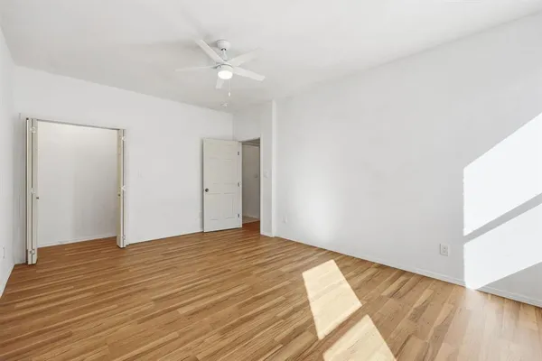 a view of empty room with wooden floor
