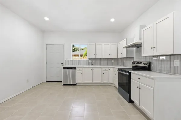 a kitchen with granite countertop white cabinets and white appliances