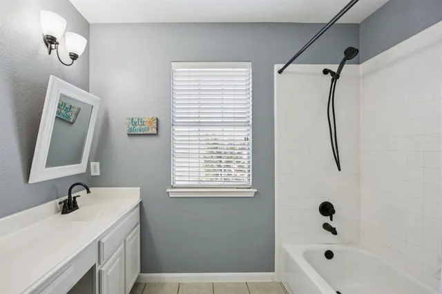 a bathroom with a tub sink and mirror