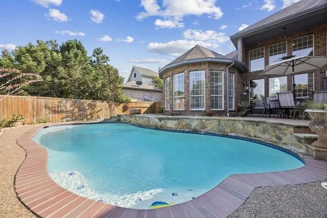 a view of a house with swimming pool and sitting area