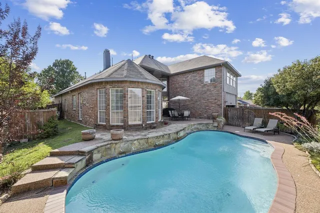 a view of a house with backyard and sitting area