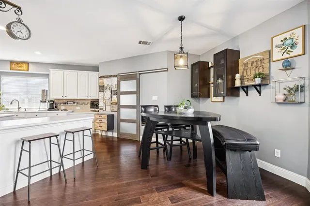 a kitchen with a table chairs and wooden floor