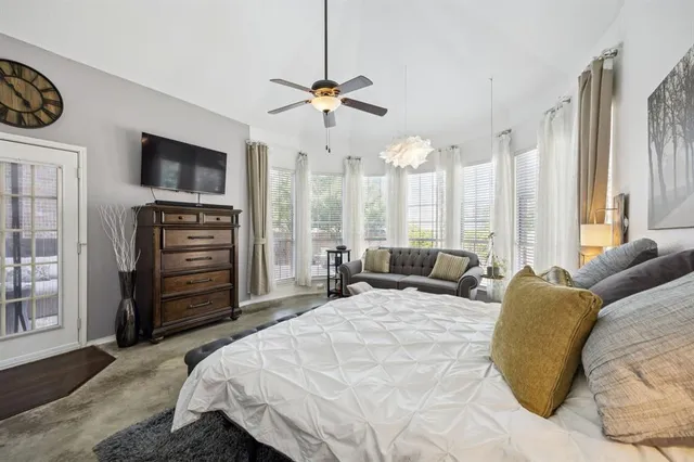 a bedroom with a bed a dresser and a flat screen tv