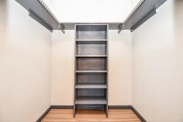 a view of walk in closet with empty racks