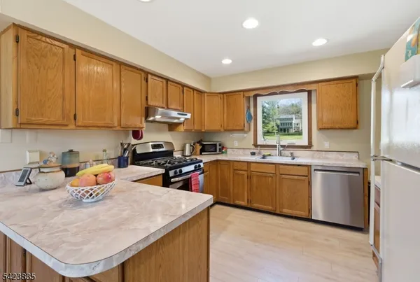 a kitchen with granite countertop a sink stove and refrigerator