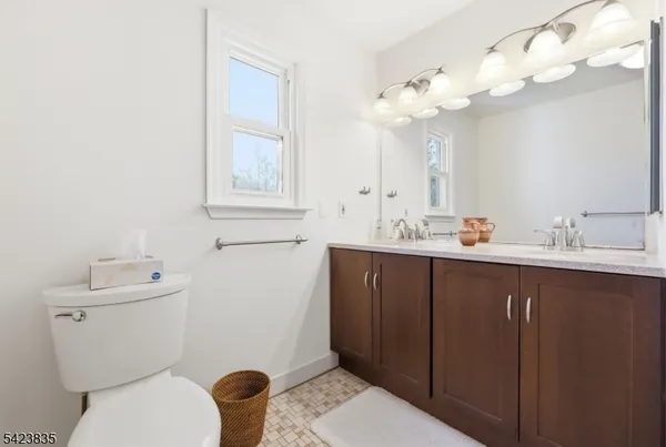 a view of a hallway with wooden floor and a bathroom