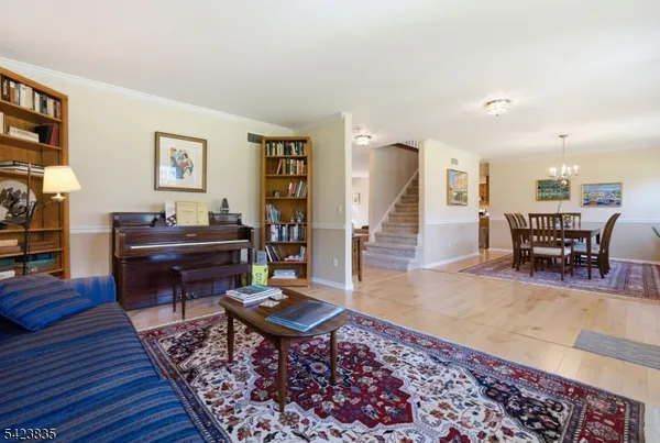 a view of a dining room with furniture a rug and wooden floor