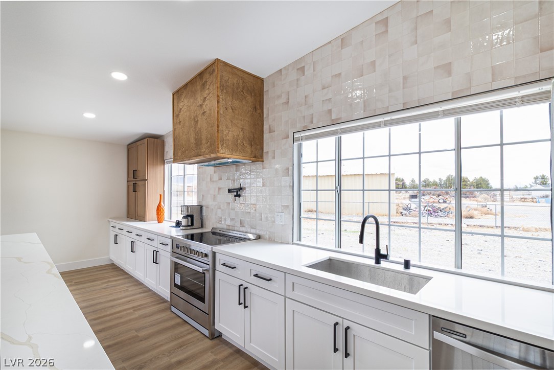 1891 Brian Road Pahrump, NV 89048 - Photo 8 of 50 Kitchen with tasteful backsplash, recessed lighting, light wood-style flooring, stainless steel appliances, and a sink