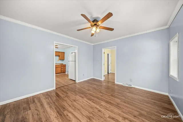 a view of a livingroom with a ceiling fan and wooden floor