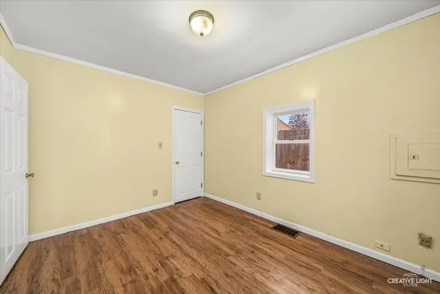 a view of a room with wooden floor and white walls