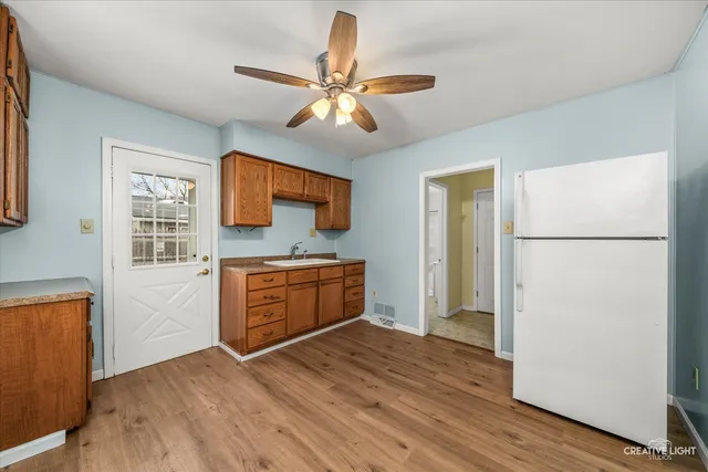 a kitchen with stainless steel appliances granite countertop a refrigerator a sink dishwasher a stove and a refrigerator with wooden floor