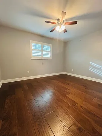 a view of a room with wooden floor and fan