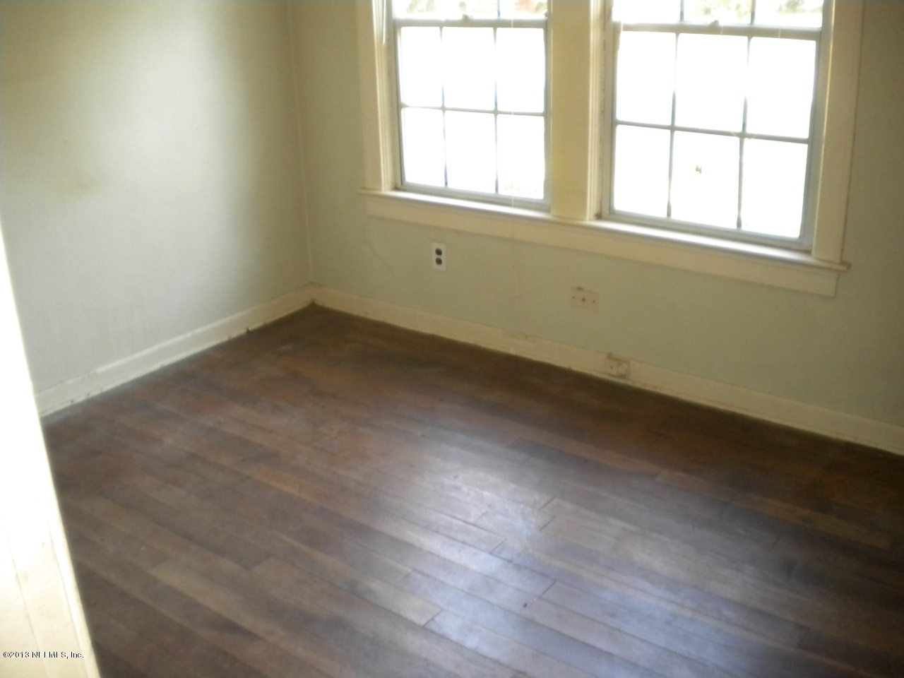 4766 Manchester Road Jacksonville, FL 32210 - Photo 4 of 10 an empty room with wooden floor and windows