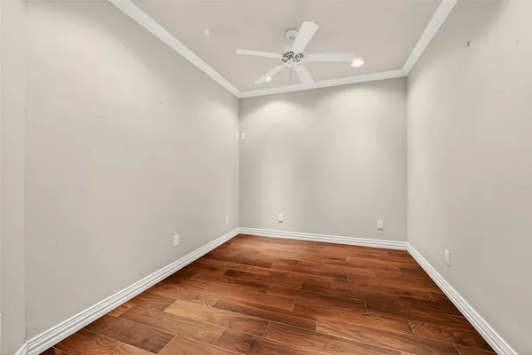 a view of an empty room with wooden floor