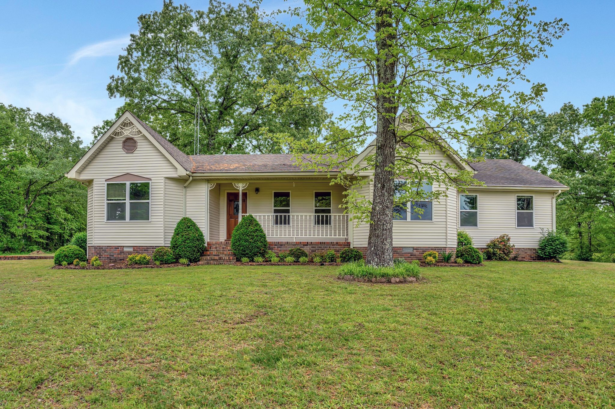 a front view of a house with a yard and trees