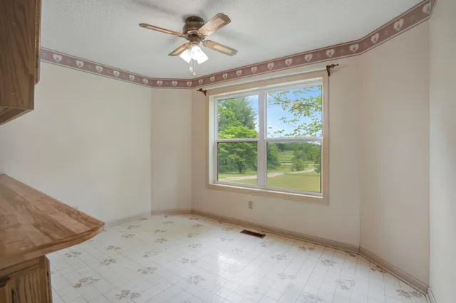 a view of a livingroom with a ceiling fan and window