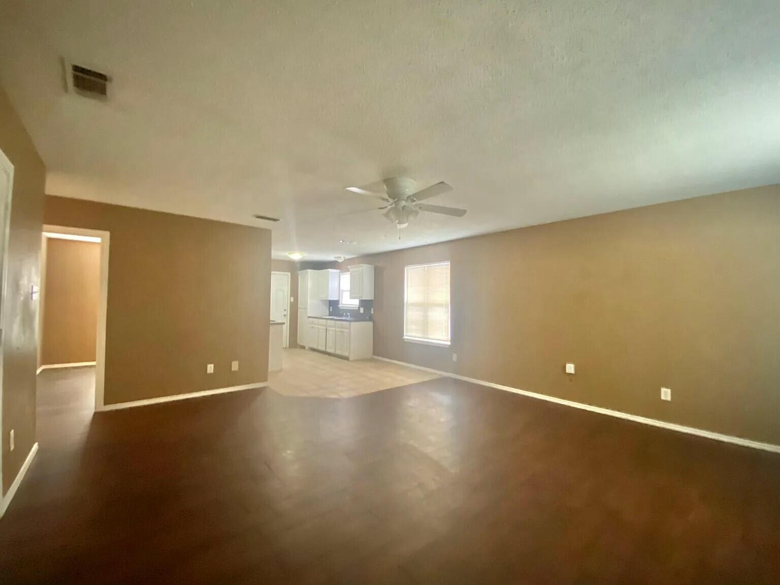 2 St Lubbock Tx 79412 Lubbock, TX 79412 - Photo 15 of 42 an empty room with wooden floor and windows with curtains