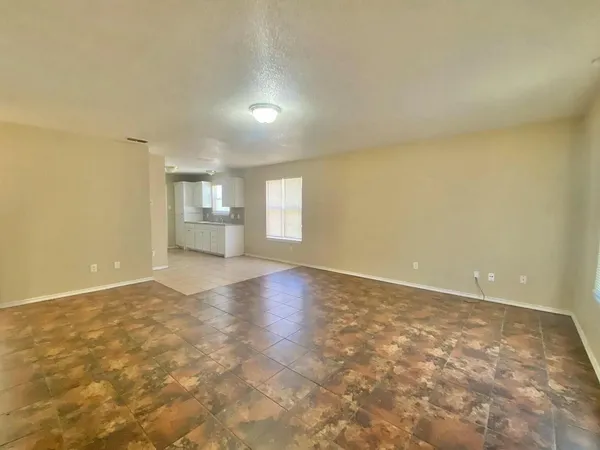 a view of a hallway with wooden floor and a bathroom