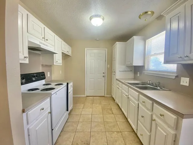 a bathroom with a granite countertop toilet sink and mirror