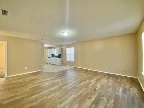 an empty room with a window and a fan