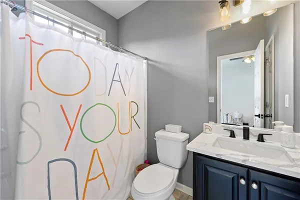 a bathroom with a granite countertop toilet sink and mirror