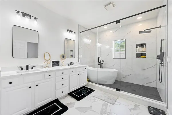a bathroom with a double vanity sink mirror and shower
