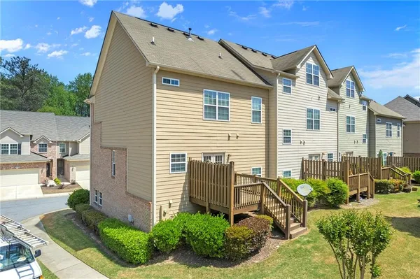 a view of a white house next to a yard