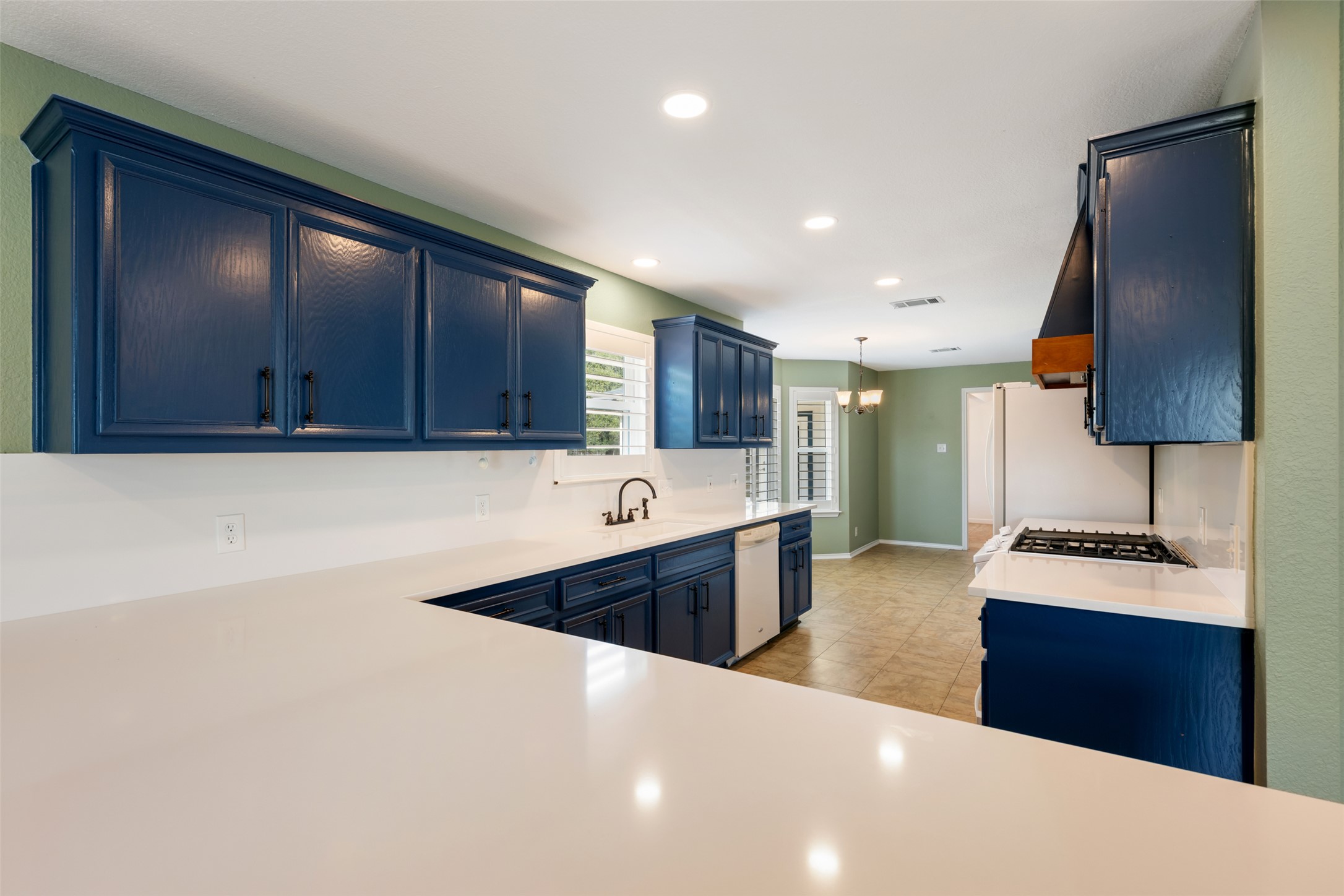 104 Sunset Road Georgetown, TX 78633 - Photo 10 of 40 a large kitchen with stainless steel appliances a sink dishwasher a stove and a refrigerator with wooden floor