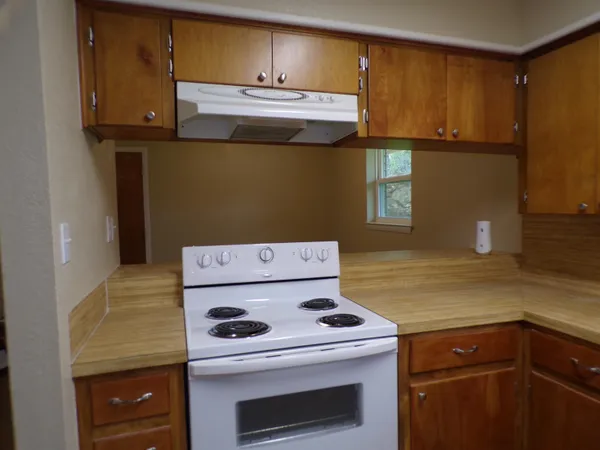 a view of a kitchen with stove and cabinets