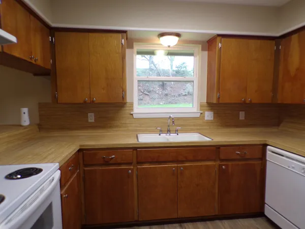 a kitchen with a sink window and cabinets