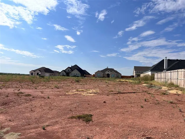 a view of a yard with wooden fence
