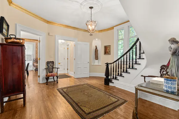 a view of a livingroom with wooden floor and a pendant light