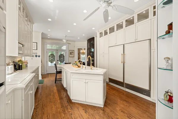 a large white kitchen with stainless steel appliances a refrigerator a stove a sink dishwasher and a oven with wooden floor