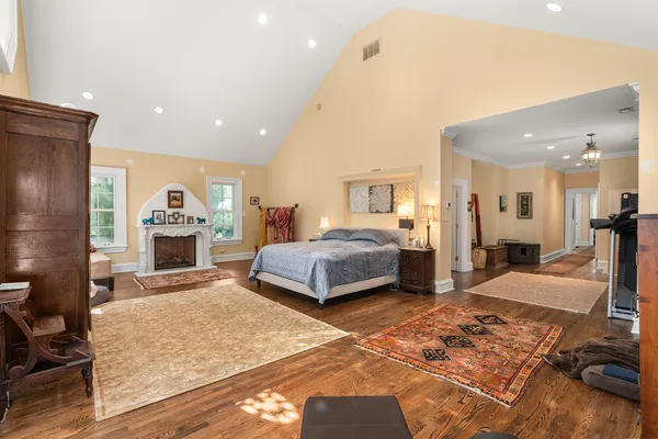 a spacious bedroom with a bed a couch and chandelier