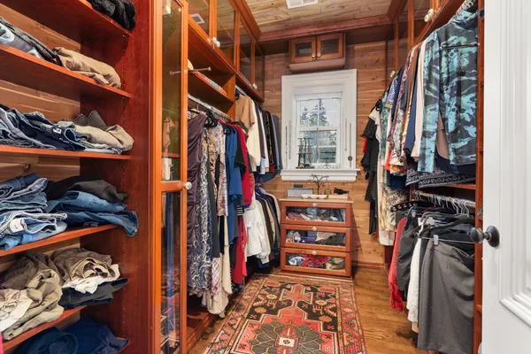 a view of walk in closet with clothes and shoes