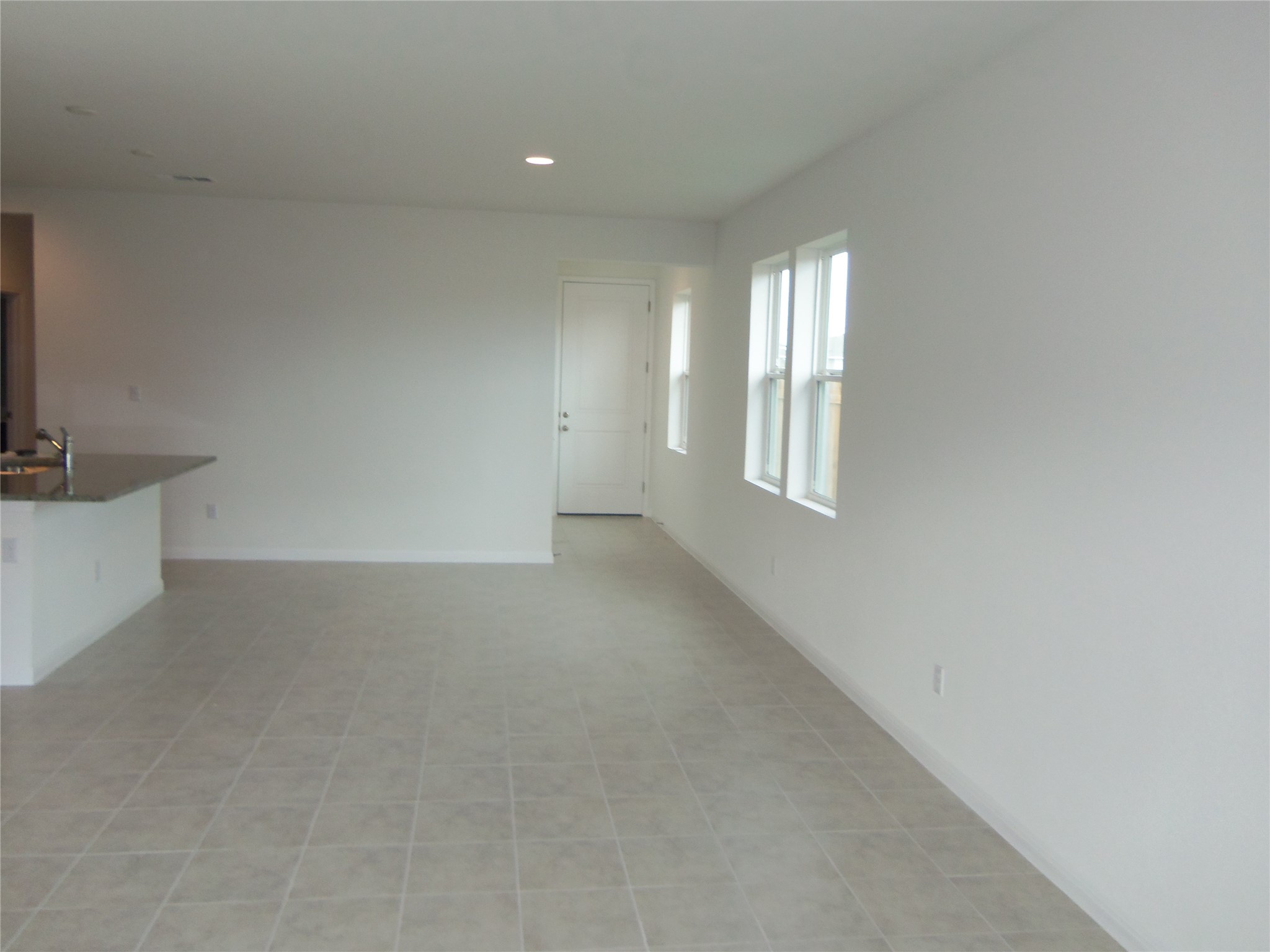 303 Cold Springs Loop Bastrop, TX 78602 - Photo 4 of 13 A spacious, naturally illuminated room featuring durable tile flooring and clean architectural lines.