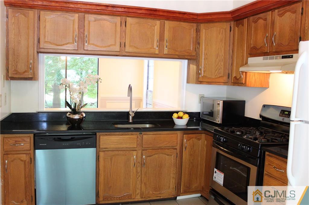 1706 Timber Oaks Road, Unit 1706 Edison, NJ 08820 - Photo 11 of 25 a kitchen with stainless steel appliances granite countertop a sink stove and cabinets