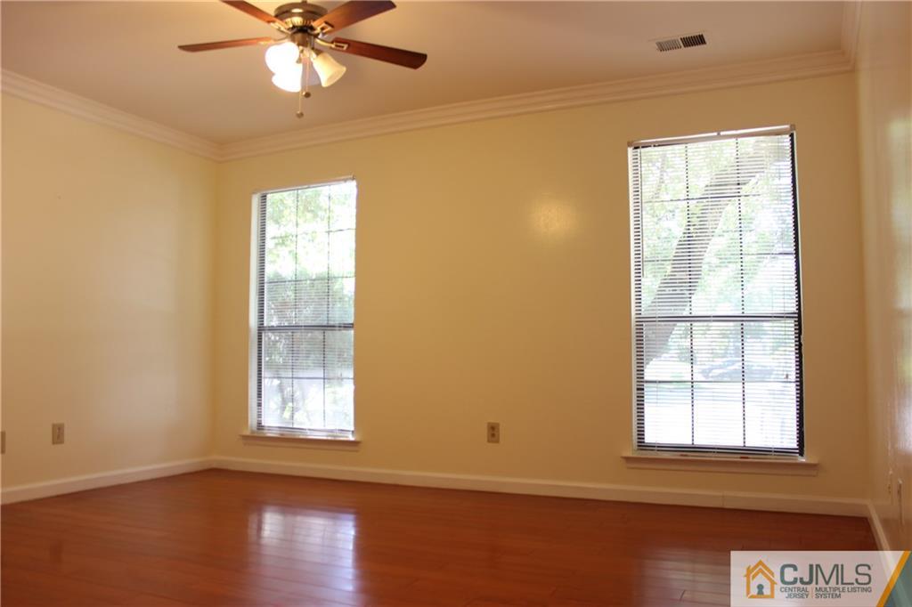 1706 Timber Oaks Road, Unit 1706 Edison, NJ 08820 - Photo 15 of 25 an empty room with wooden floor chandelier fan and windows