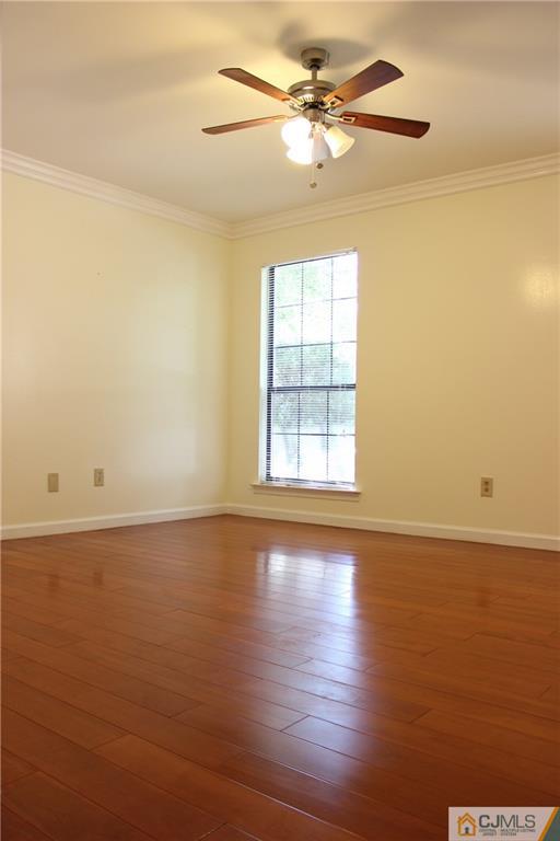 1706 Timber Oaks Road, Unit 1706 Edison, NJ 08820 - Photo 16 of 25 an empty room with wooden floor fan and windows