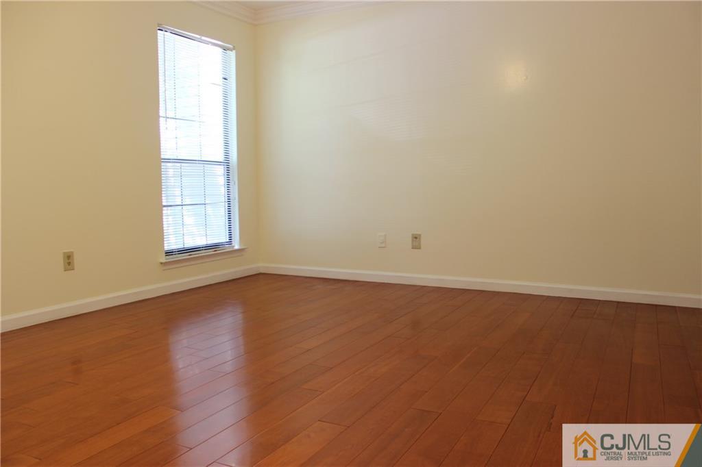 1706 Timber Oaks Road, Unit 1706 Edison, NJ 08820 - Photo 17 of 25 an empty room with wooden floor and windows