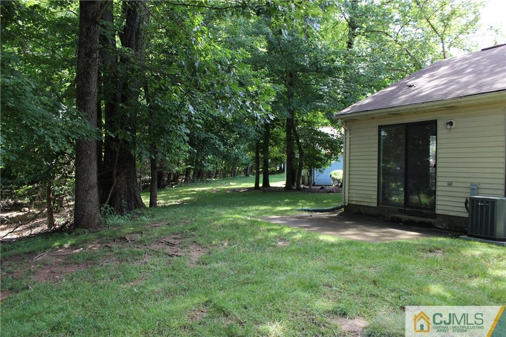 1706 Timber Oaks Road, Unit 1706 Edison, NJ 08820 - Photo 24 of 25 a view of a backyard with a large tree