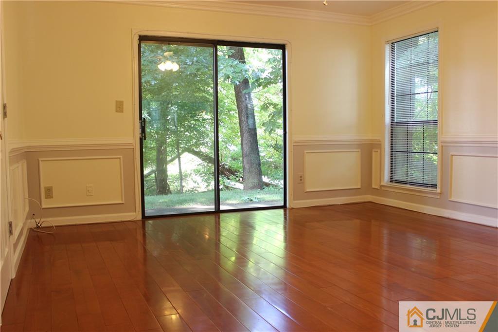1706 Timber Oaks Road, Unit 1706 Edison, NJ 08820 - Photo 4 of 25 a view of an empty room with wooden floor and a window