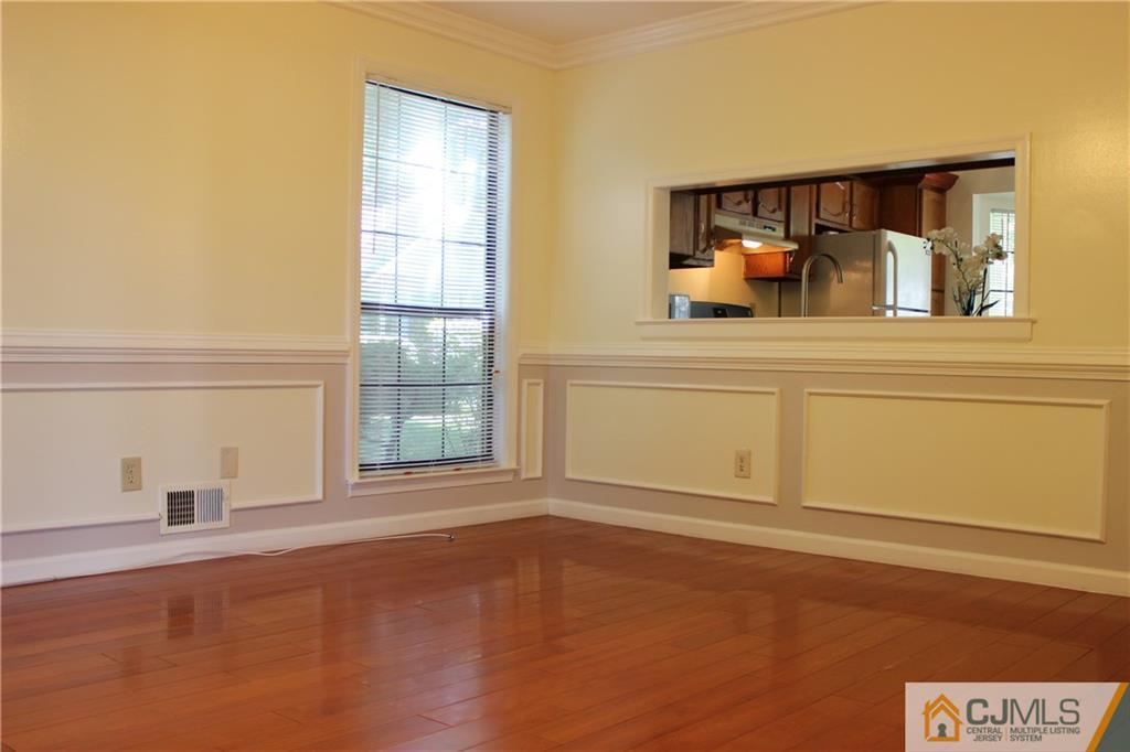 1706 Timber Oaks Road, Unit 1706 Edison, NJ 08820 - Photo 5 of 25 a view of an empty room with window and wooden floor