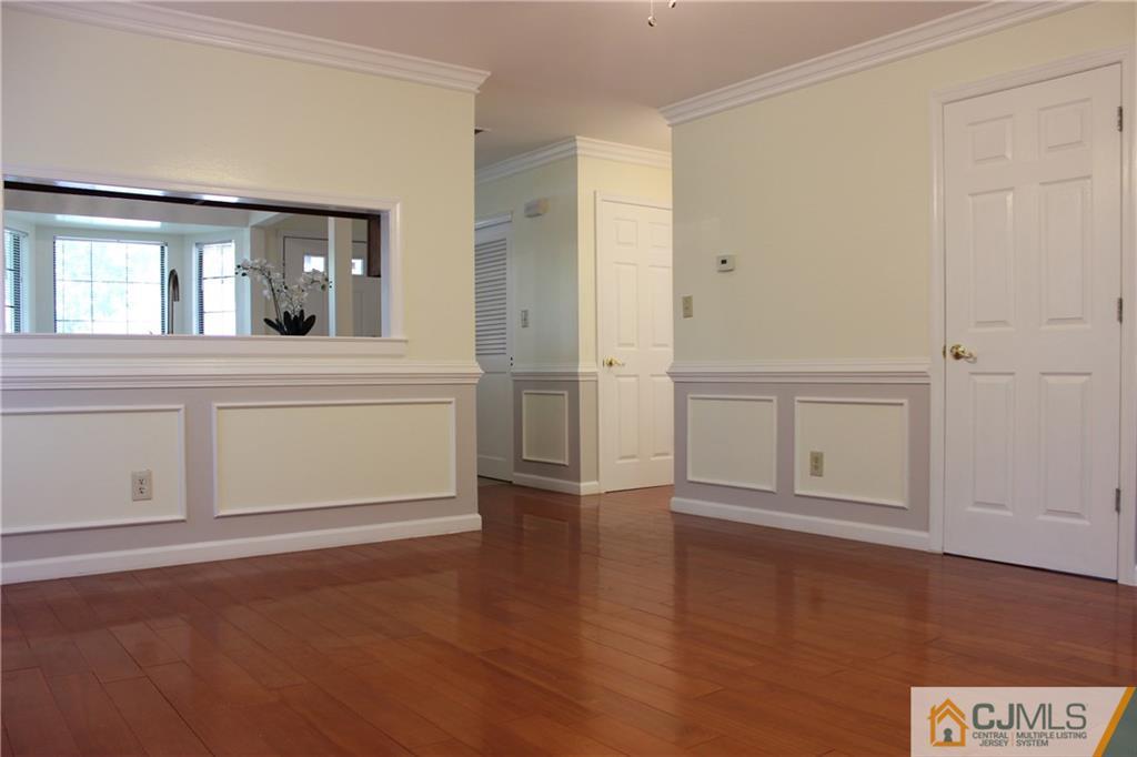 1706 Timber Oaks Road, Unit 1706 Edison, NJ 08820 - Photo 9 of 25 an empty room with wooden floor cabinet and windows